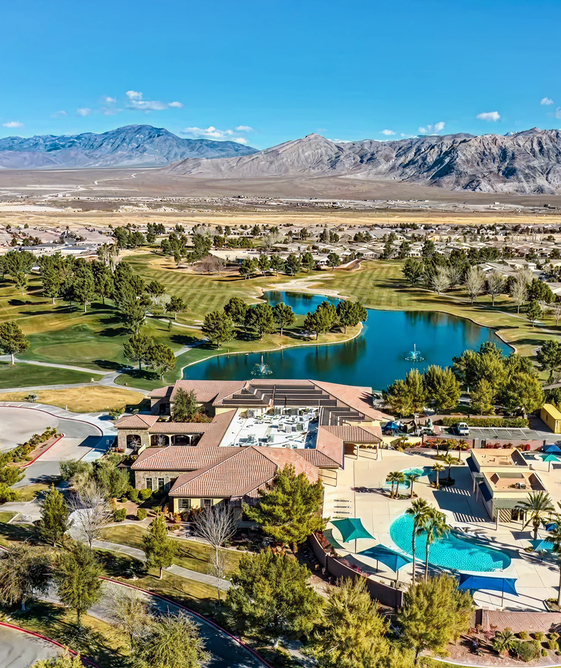 Aerial view of neighborhood with pool and mountain backdrop