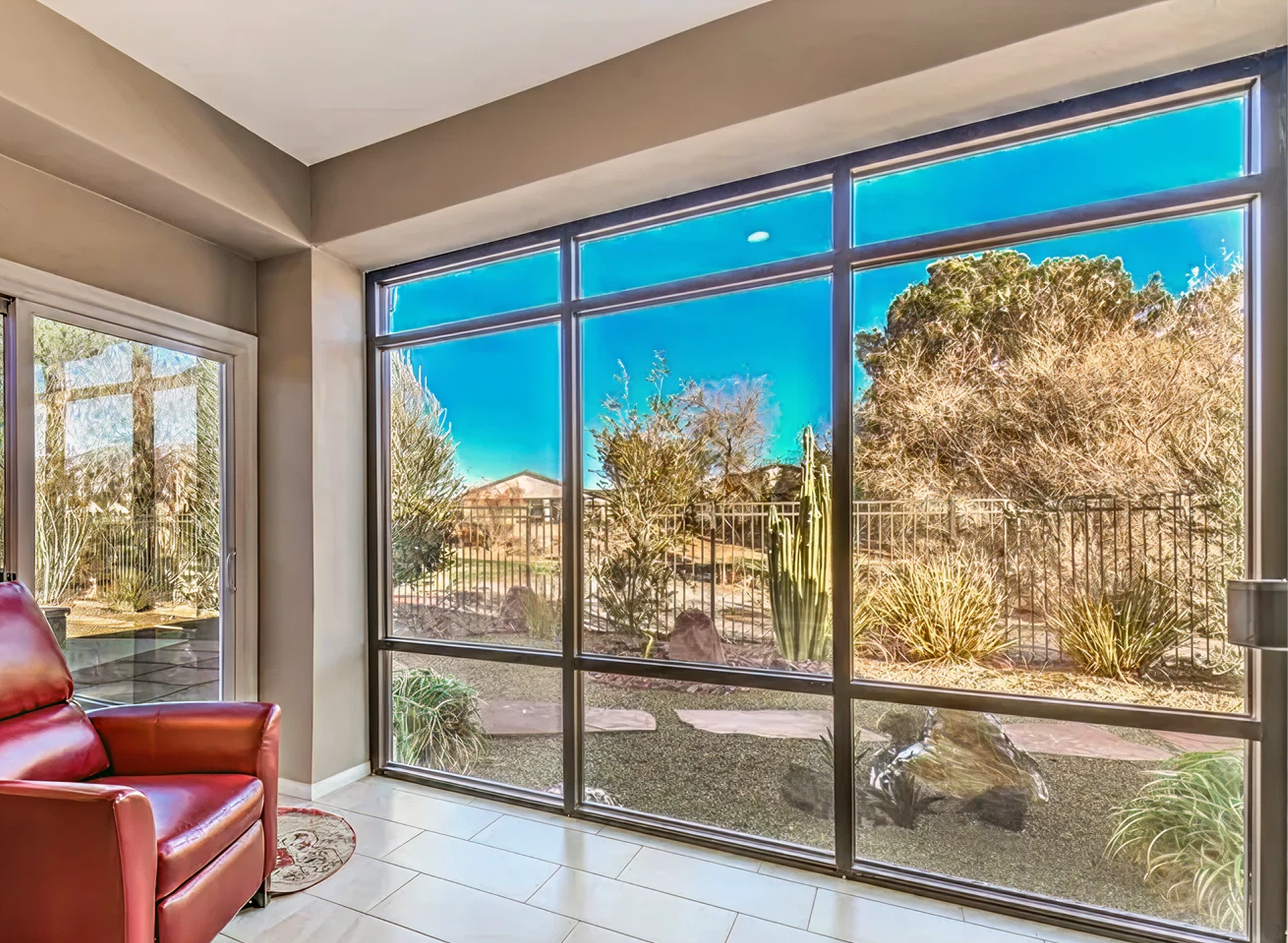 Living room with red recliner and large windows overlooking desert landscape